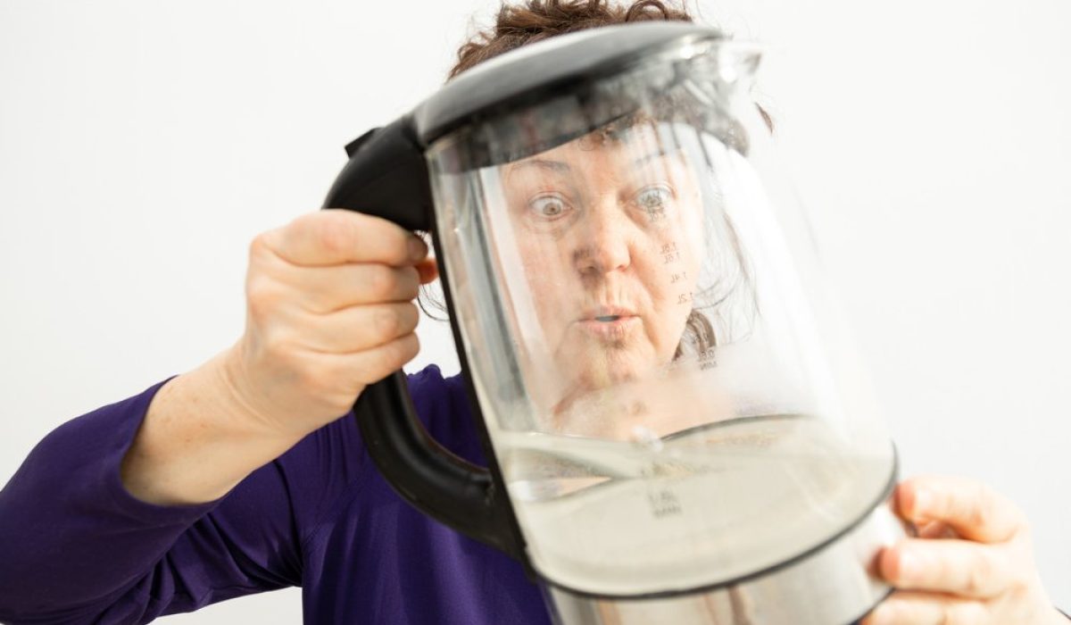 Woman,Looks,Through,A,Transparent,Electric,Kettle,With,Limescale.,Chalk Woman,Looks,Through,A,Transparent,Electric,Kettle,With,Limescale.,Chalk
